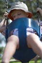 Young boy on swing at playground Royalty Free Stock Photo