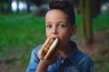 A young boy takes a bite of a hot dog Royalty Free Stock Photo