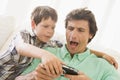 Young boy taking handheld game from man