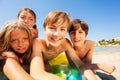 Young boy taking selfie with friends on the beach Royalty Free Stock Photo