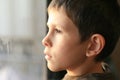 Young boy in thought with window reflection Royalty Free Stock Photo