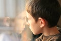 Young boy in thought with window reflection Royalty Free Stock Photo