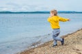 Young boy throwing stones in sea water