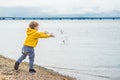 Young boy throwing stones in sea water Royalty Free Stock Photo