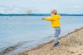 Young boy throwing stones in sea water Royalty Free Stock Photo