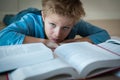 Young boy tired of reading, kid having too much homework