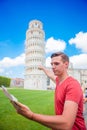 Young boy with toristic map on travel to Pisa. Tourist traveling visiting The Leaning Tower of Pisa. Royalty Free Stock Photo