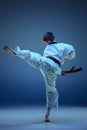 Young boy training karate on blue background Royalty Free Stock Photo