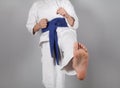 Young boy training karate on gray background. Boy with a kimono Royalty Free Stock Photo