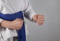 Young boy training karate on gray background. Boy with a kimono Royalty Free Stock Photo