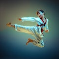 Young boy training karate on blue background Royalty Free Stock Photo