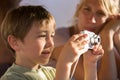 Young boy tries camera with his mother