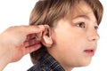 Young boy trying a hearing aid. Isolated on white background Royalty Free Stock Photo