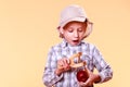 Young boy use sling shot hold apple.