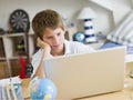 Young Boy Using A Laptop In His Bedroom Royalty Free Stock Photo