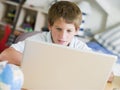 Young Boy Using Laptop In His Bedroom Royalty Free Stock Photo