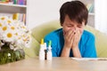 Young boy with various nose sprays sneezing in allergy season