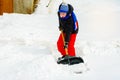 A young boy in the village cleans the snow and makes a walk Royalty Free Stock Photo