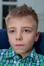 Young boy watch television in living room. Kid with blue eyes while watching TV. Close up view Royalty Free Stock Photo