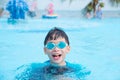 Young boy wearing goggles swimming in swimming pool Royalty Free Stock Photo