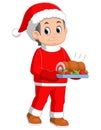 Young boy wearing santa costume showing roast beef on dish