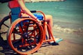 Young boy on the wheelchair on the beach by the sea