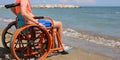 Young boy on the wheelchair on the beach in summer