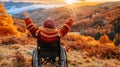 Young boy in wheelchair raising arms, delighting in sunset amidst mountain backdrop