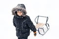 Young boy in winter suit pulling sledges Royalty Free Stock Photo