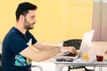 Young boy working with his laptop from the outside terrace of a bar in Spain. Telecommuting, space for text, copyspace Royalty Free Stock Photo