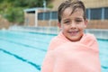 Young boy wrapped in towel standing at poolside Royalty Free Stock Photo