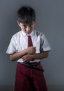 Young child in school uniform feeling sad and depressed looking down scared and embarrassed victim of bullying and abuse Royalty Free Stock Photo