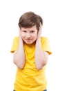 Young boy in yellow t-shirt shuts his ears by hands Royalty Free Stock Photo