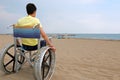 Young boy with yellow tshirt on the beach on the wheelchair Royalty Free Stock Photo