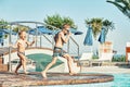 Young boys with bare torsos jumping into swimming pool