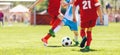 School Kids in Red and Blue Jersey Uniforms Running Classic Soccer Ball on Grass Pitch Royalty Free Stock Photo