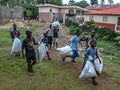 Village children pick up trash for payment by missionaries in rural Haiti.