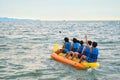 Young boys and girl riding on the banana boat on the sea in Pattaya, Thailand.