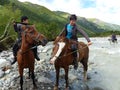Young boys on horses in a river in Svanetie in Georgia.