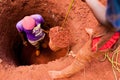 Young boys manually digging well with bucket full of soil in african small village