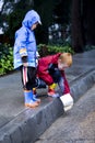 Young boys playing with toy boat in the rain 2 Royalty Free Stock Photo