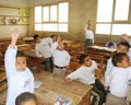 Young boys raising hands for answer question