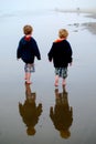 twin boys with reflections on beach Royalty Free Stock Photo