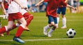 Young Boys in White and Red Soccer Jersey Shirts and Soccer Cleats Kicking Soccer Ball Royalty Free Stock Photo
