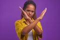 Young brave African American woman makes prohibition sign with hands in studio