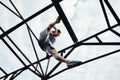 Young brave man sitting on the top of high metal construction