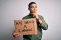 Young brazilian activist man asking for change holding banner over white background serious face thinking about question, very Royalty Free Stock Photo