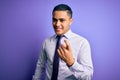 Young brazilian businessman wearing elegant tie standing over isolated purple background Beckoning come here gesture with hand