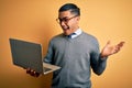 Young brazilian businessman working using laptop standing over isoltated yellow background very happy and excited, winner Royalty Free Stock Photo