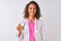 Young brazilian doctor woman holding glass of water standing over isolated white background with a happy face standing and smiling Royalty Free Stock Photo